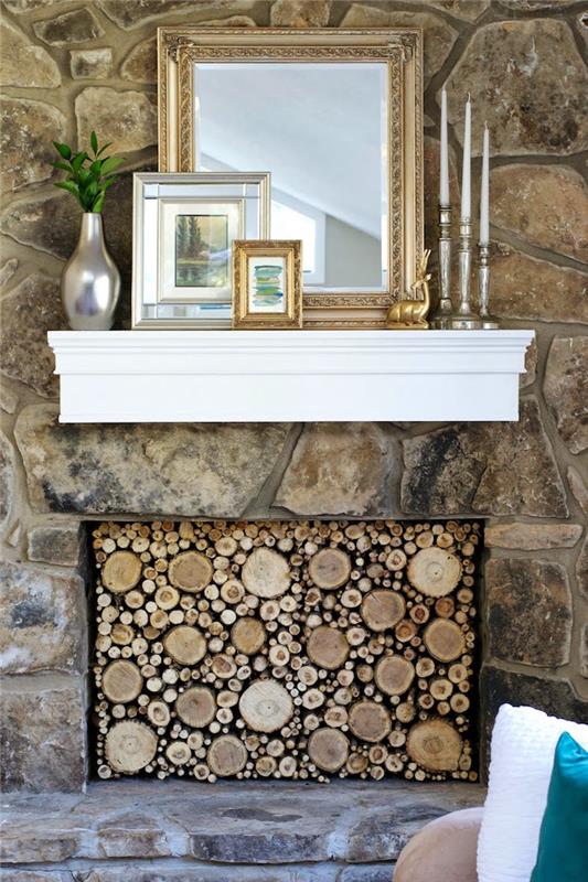 vidinė akmens siena su dirbtiniu židiniu židiniu su dekoratyviniais rąstais ir baltu veidrodiniu sieniniu laikikliu bei nuotraukų rėmeliais