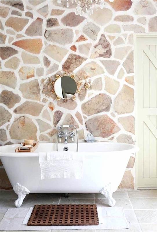 spalvota akmeninė vonios siena su baltu kalkių skiediniu ir laisvai stovinčia vonia