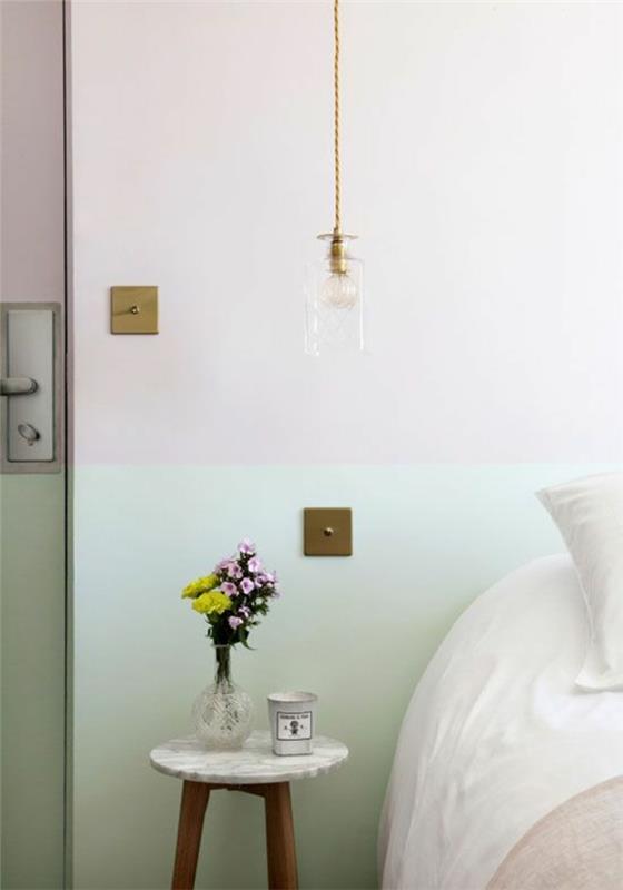 altın kablo ile camdan eski bir başucu sarkıt lamba, pastel tonlarda bir yatak odası, mermer ve ahşap komodin