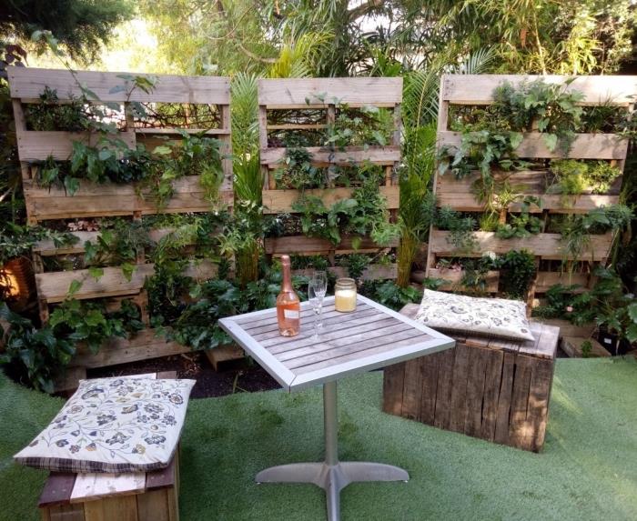 Sahte çim halı ve geri dönüştürülmüş ahşap mobilyalarla bir bahçe nasıl düzenlenir, palet yeşili duvar örneği