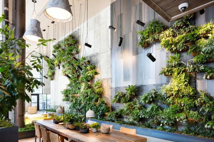 pramoninio stiliaus virtuvė su žalia siena viduje, pramoninio stiliaus šviestuvai iš sidabro spalvos metalo, sienos padengtos pilku metalu
