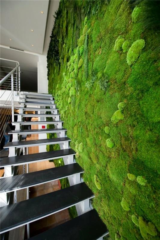 surenkami laiptai, palėpės stiliaus namas, didelė vidinė žalia siena, minimalistinis interjeras