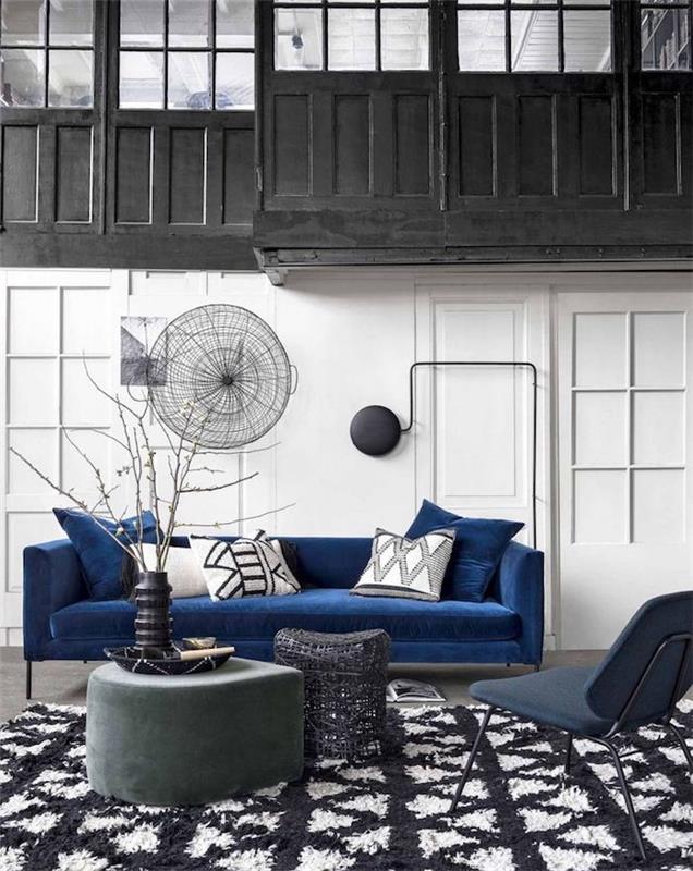 črno -bela dnevna soba z modrim naglasom temno modra zofa, črno -bela preproga, bele stene