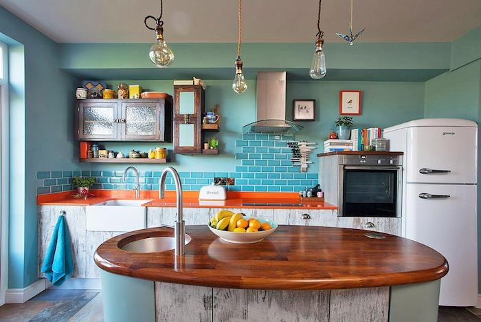 bir mutfağın duvarları için ne renk, orijinal fikir turkuaz duvar tablosu, orta ahşap ada, turuncu tezgah, beyaz buzdolabı