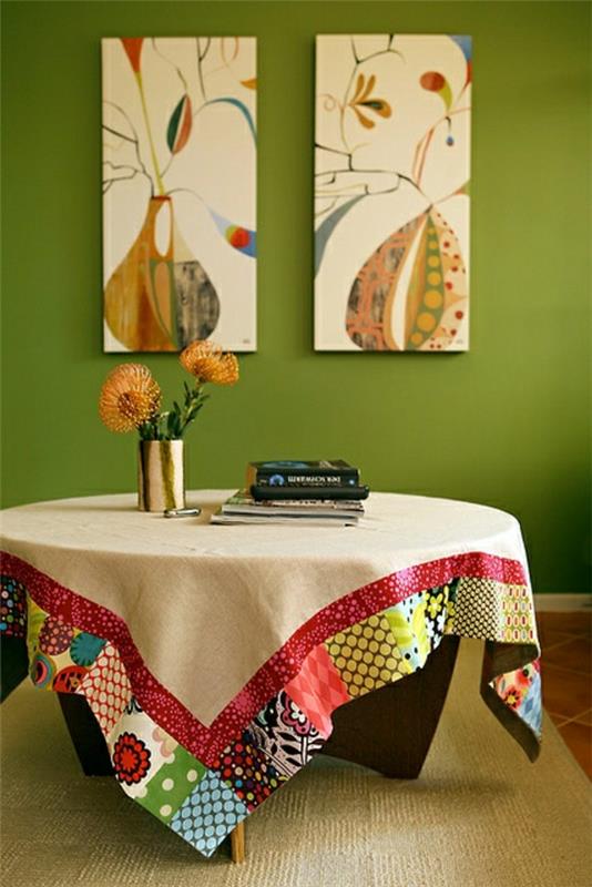 smėlio spalvos staltiesė-medinis kavos staliukas-gėlės-žalia siena