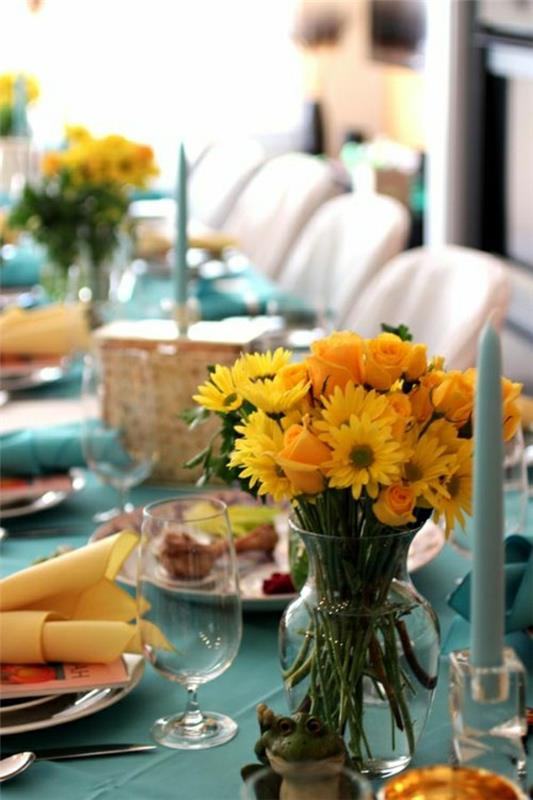 staltiesė-mėlyna-gėlės-geltona-servetėlė-geltona-žvakė-mėlyna-gėlės