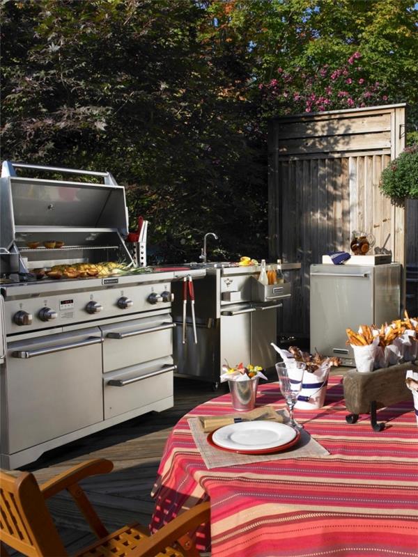 barbekü ve açık lavabo ile donatılmış mutfak ile bahçe dekorasyonu, kırmızı masa örtüsü ile yuvarlak bir masa nasıl düzenlenir