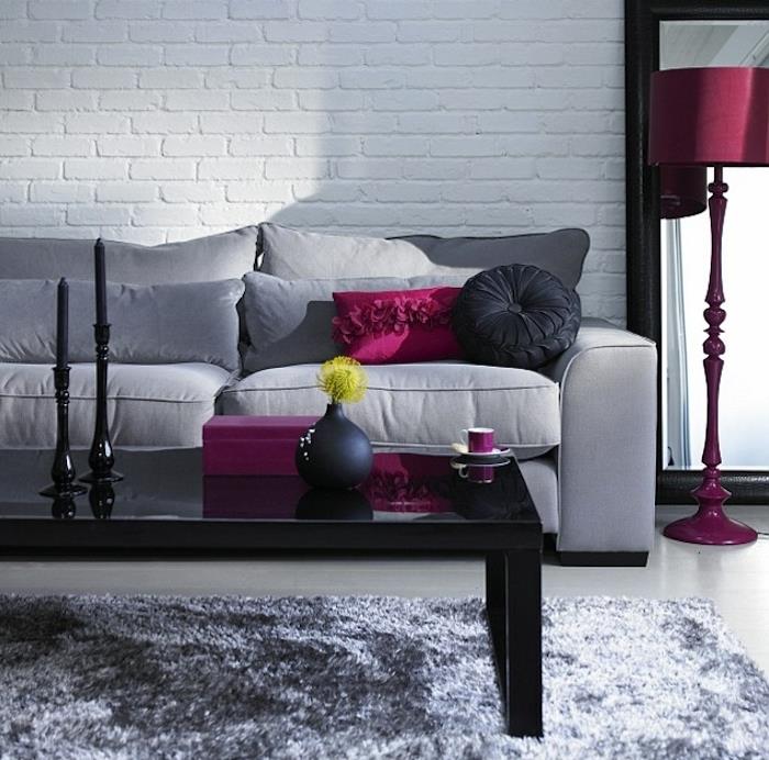 pilka sofa, rožinės ir juodos spalvos pagalvės, rožinis lempos stovas, pilkos spalvos, juodas kavos staliukas