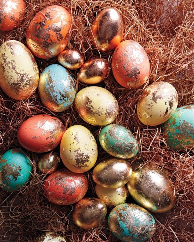 Pastel tonlarda renkli yumurta modelleri ve metalik efektli altın yapraklar ile düğüm şeklinde Paskalya masa dekorasyonu