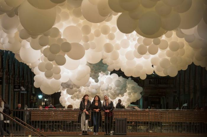instaliacija „Covent Garden“, didelės baltų balionų grupių pakabos nuo pastato lubų ir žiūrovai