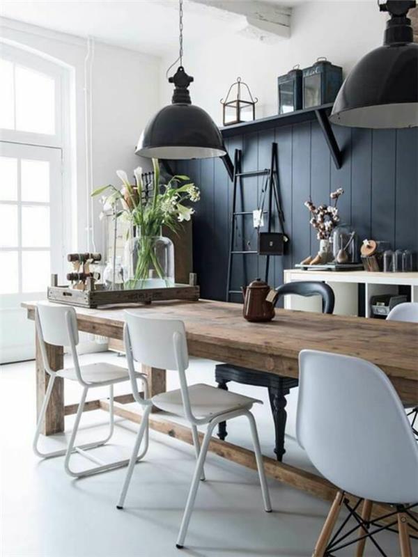 odtenek modre barve modro siva z lesenimi oblogami pobarvana v barvo velika lesena miza v jedilnici s temno sivimi n svetilkami v industrijskem slogu