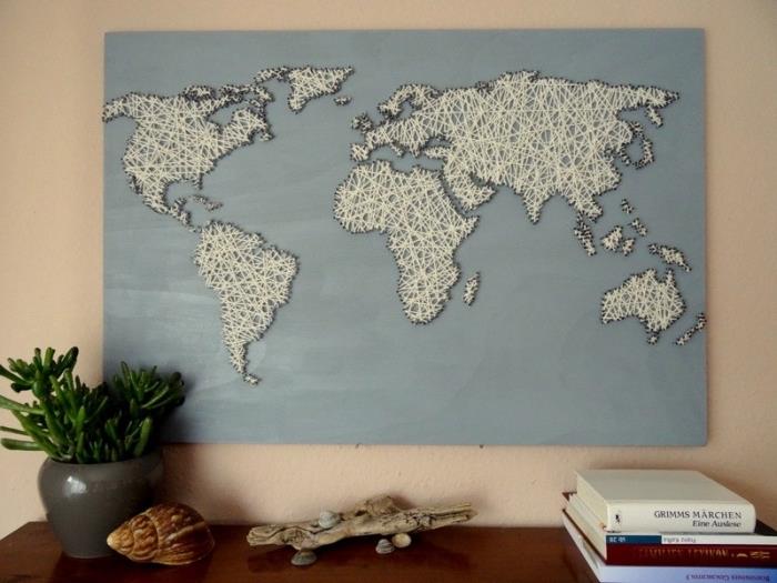 didelis medinis paveikslas, nudažytas šviesiai mėlyna spalva, pasaulio žemėlapis baltu siūlu ir kontūrai juodu siūlu, kaip paprastas pasidaryk pats objektas