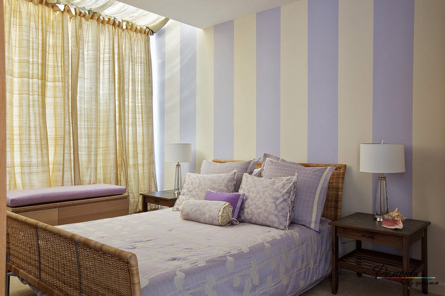 壁に明るい縞模様の壁紙が付いている寝室