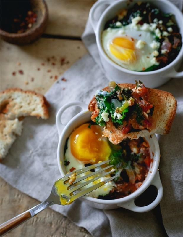 ıspanaklı yumurta güveçleri ve çıtır çıtır tost ile zevk için ramekinlerde hazırlanmış peynir, akşam veya öğle yemeği için hızlı tarif