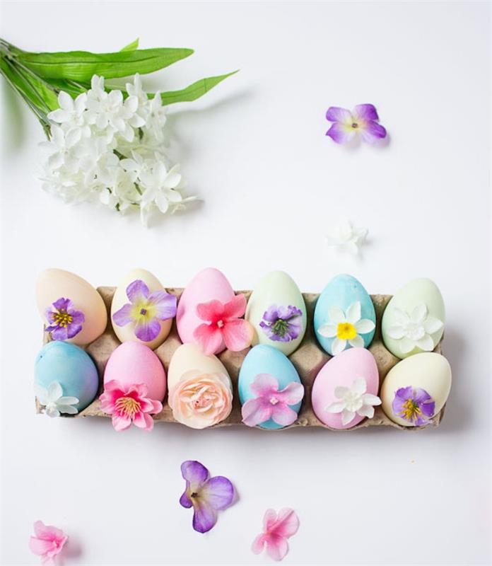 Farklı tonlarda renkli yumurtalar, ana parçanız için küçük çiçeklerle süslenmiş, Paskalya el kitabı etkinliği