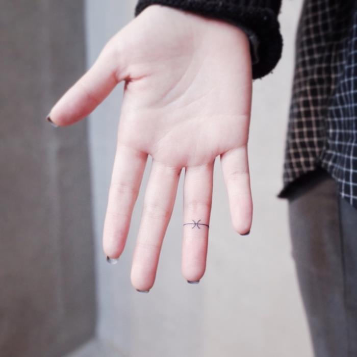 primer mini tetovaže na prstu v obliki minimalističnega prstana za dragulje, model tetovaže za ženske