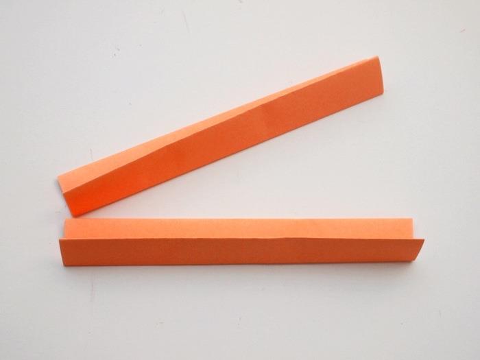 oranžinis popierius, sulankstytas į dvi dalis, baltame fone, „Dun“ žaidimai vaikams, žingsnis po žingsnio, „pasidaryk pats“ pamoka