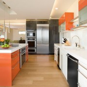 Oranžinis stalas naudojamas kaip akcentas virtuvės interjere