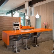 Baro skaitiklis su oranžiniu stalviršiu - ryškus virtuvės interjero akcentas