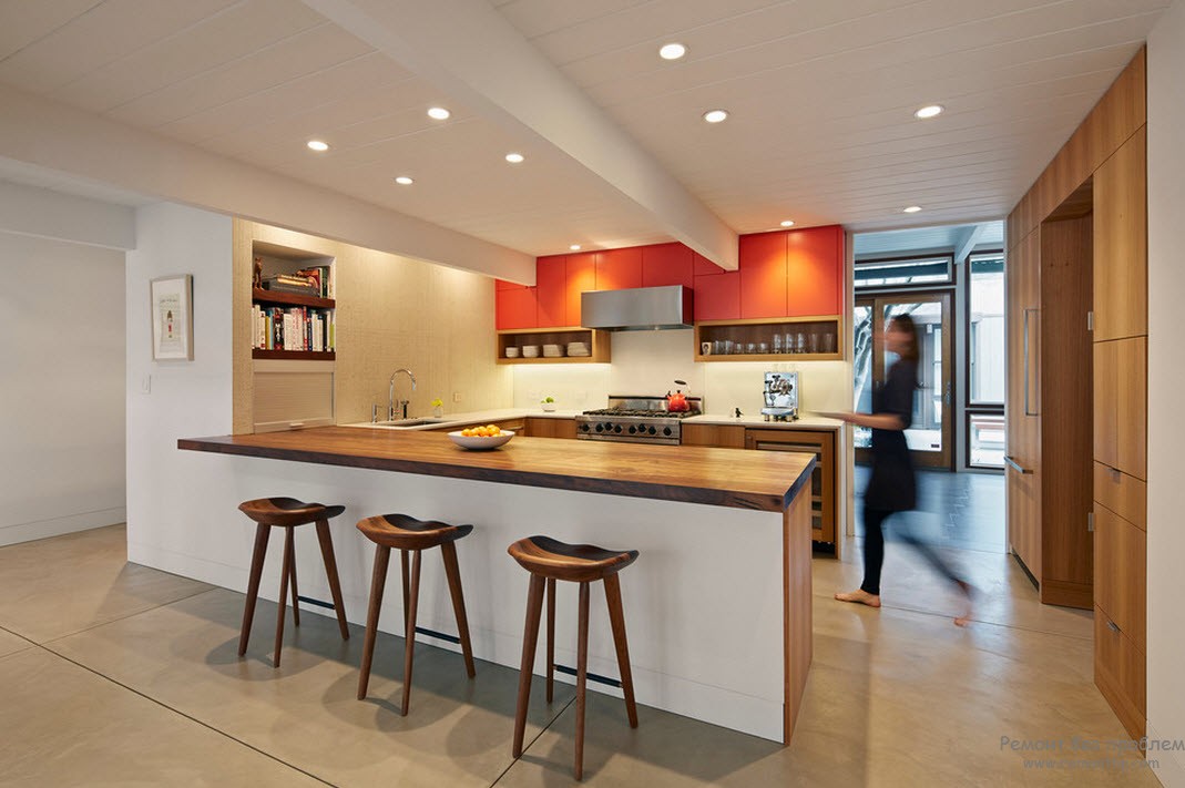 Oranžinės sieninės spintelės veikia kaip virtuvės interjero akcentas