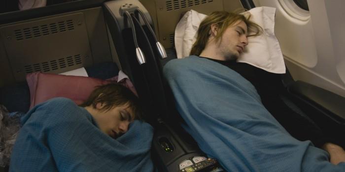 Du jaunuoliai miega lėktuve