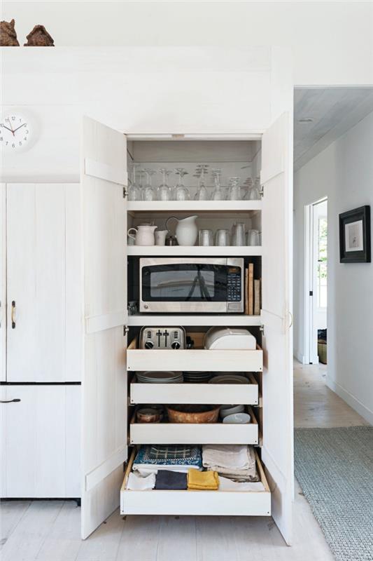 spintelės viduje su lentynomis ir stumdomais stalčiais, kurioje taip pat yra mikrobangų krosnelė, virtuvės spintelių išdėstymas, kad būtų geriau sutvarkyti jūsų indai ir virtuvės skalbiniai