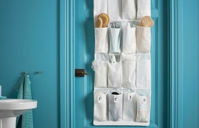 vonios organizatorius ant sandėliavimo durų su mėlynomis durų kišenėmis vonios reikmenys