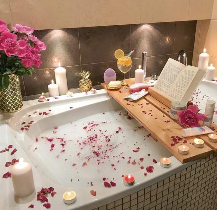 organizuoti kokonuojantį vakarinį SPA namelį vonia rožių žiedlapiai o = žvakės vonios denio skaitymo kokteilis