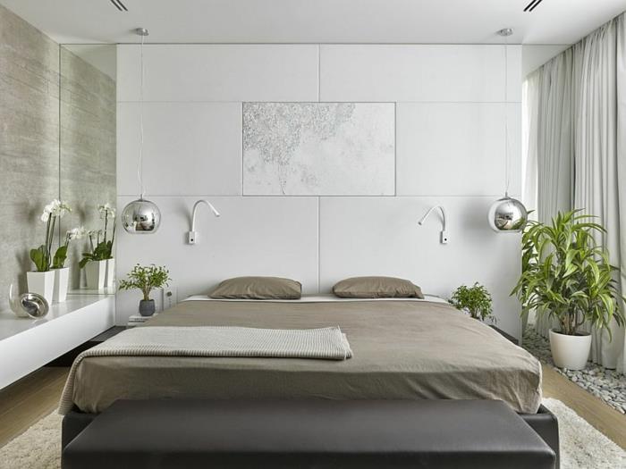 siva postelja, bela preproga, belo vzdušje in kromirane viseče svetilke v spalnici po feng shuiju