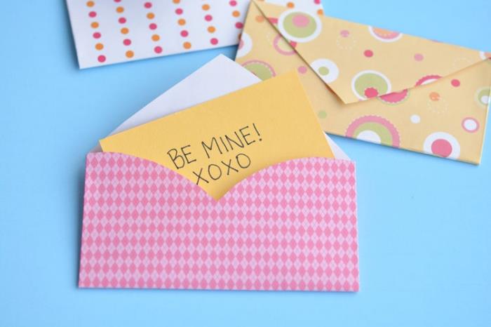 sarı not öpücükleri ile geometrik tasarımlı pembe kağıttan bir zarf, DIY zarf şablonu yapın