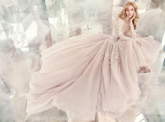 originalios šviesiai rožinės vestuvinės suknelės pavyzdys su viršuje su gėlėtomis rankovėmis ir pasakiškas rožinis sijonas