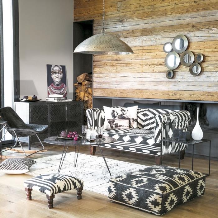 Afrikos stiliaus apdaila su „Navajo“ daiktais ir geležiniais baldais, balto etninio kilimo raštu, balta ir juoda sofa su etniniais raštais