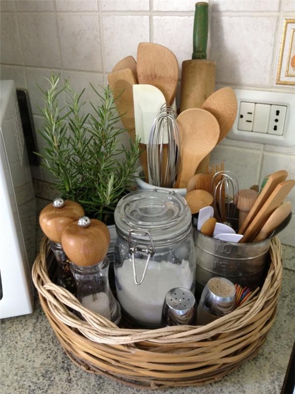 paprastas laikymo krepšelis iš natūralių pluoštų, kuriame telpa dažniausiai naudojami virtuvės reikmenys ir stiklainiai su prieskoniais, paprastas virtuvės laikymo triukas, leidžiantis išvalyti stalčius ir stalviršį