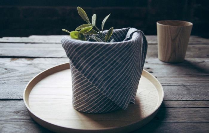 Küçük bir sepete katlanmış grafik kumaş peçete, rustik tarzda bir masayı süslemek için kolay ve hızlı origami Paskalya katlama deseni