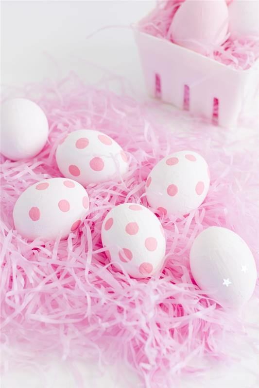 Velykų stalo puošmena balta ir rožinė, Velykų lankas su rausvo popieriaus juostelėmis ir baltais kiaušiniais su šviesiai rožiniais taškeliais