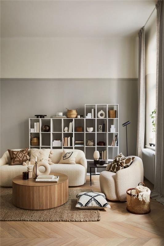 bej kumaş mobilyalar ve ahşap aksanlarla döşenmiş bej ve gri duvarlara sahip çağdaş daire dekoru