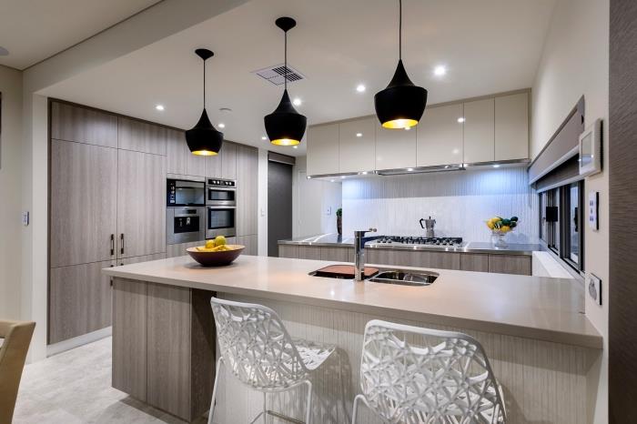 beyaz ve ahşap mutfakta modern modaya uygun iç tasarım, ada ve asma lambalı mutfak düzeni örneği