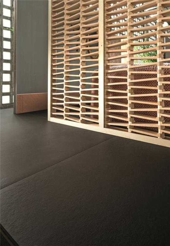 skydas iš šviesios medienos, su daugybe angų, ažūriniai efektai, kambario pertvara su antracito pilkos spalvos grindimis