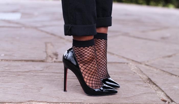 eleganco in privlačnost s črnimi lakiranimi čevlji z visokimi petami, oblečenimi v mrežaste nogavice in črne hlače