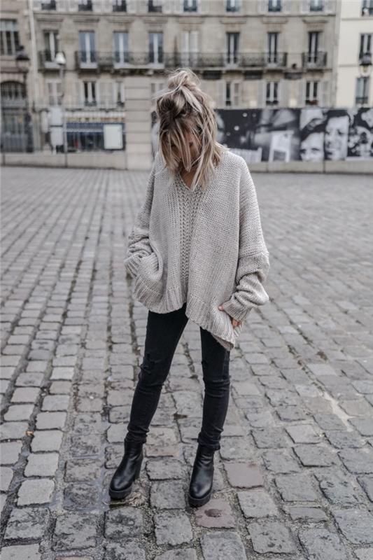 žiemos moters mada per dideliu megztiniu, atsitiktinio prašmatnaus drabužio idėja juodos spalvos kelnėmis, dėvėtomis su dideliu pilkos spalvos megztiniu