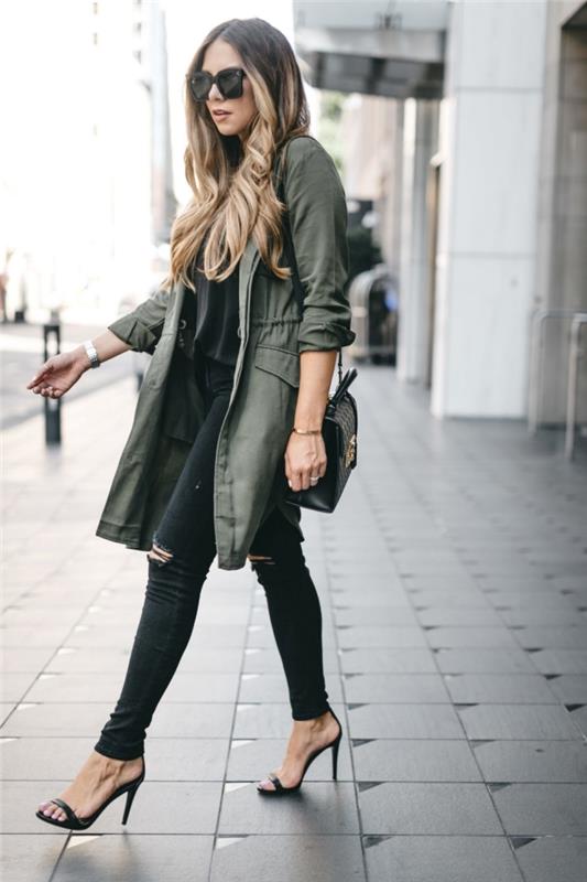 model ženske jakne kaki barve s krojem srednje dolžine, priložnostne elegantne obleke z raztrganimi hlačami in črnimi visokimi čevlji