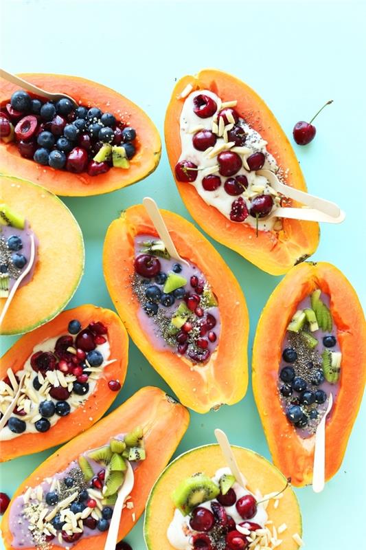 idėja sveikiems pusryčiams iš dubenėlių papajos su salotomis iš šviežių vaisių, sėklų ir jogurto