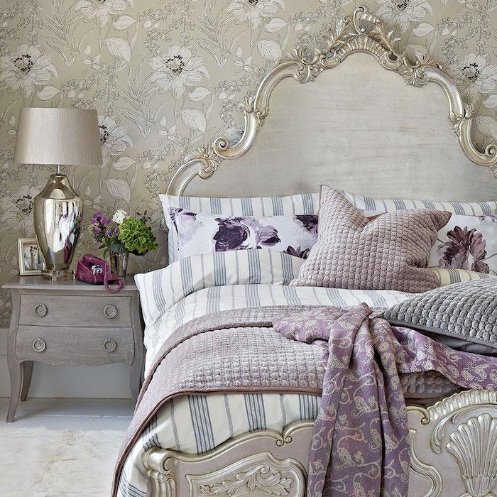 barok duvar kağıdı örneği, beyaz çiçekli gri duvar kaplaması, barok arabesk yatak, beyaz, mavi ve mor nevresim, yumuşak halı, gri komodin