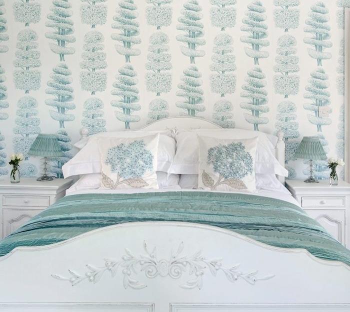 yatak odası goblen modeli, beyaz zemin üzerine yeşil ağaçlar, ördek mavisi battaniyeli beyaz yatak, barok duvar kağıdı örneği