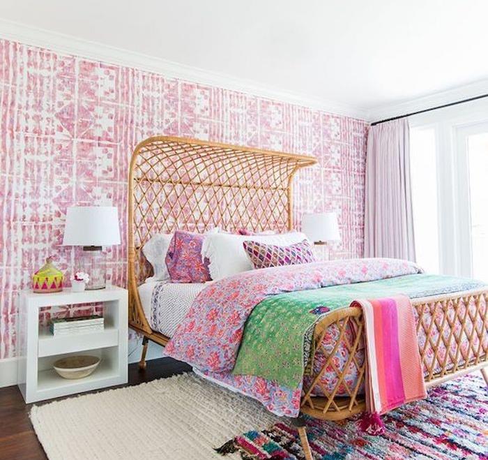 pembe ve beyaz oryantal duvar kağıdı, egzotik yatak, nevresim ve renkli halı, beyaz komodin ile yetişkin yatak odası dekorasyonu