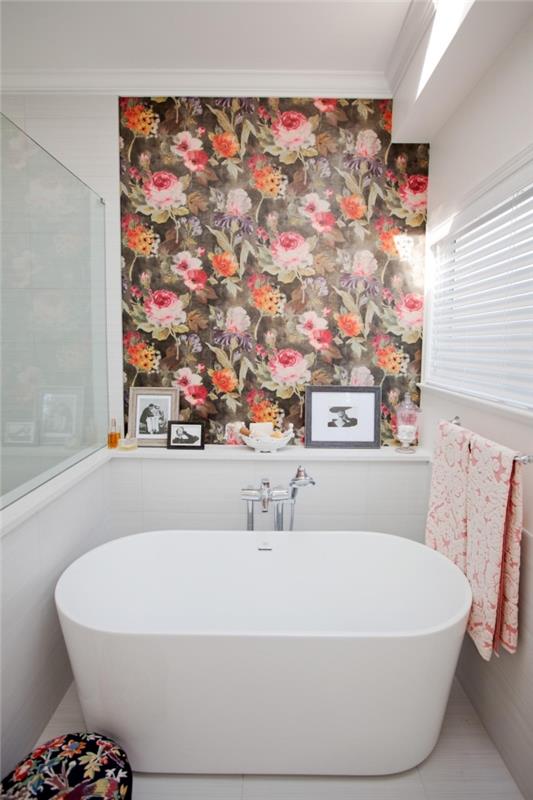 Küçük banyoda derinlik etkisi yaratmak için küvetin üzerine küçük bir dokunuşla yerleştirilmiş çiçek desenli modern duvar kağıdı