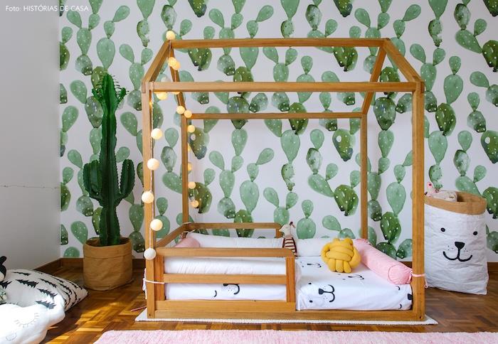 çocuk duvar kağıdı, beyaz zemin üzerine yeşil kaktüsler, ahşap kabin yatağı, beyaz yatak, pembe halı, dekoratif hafif çelenk