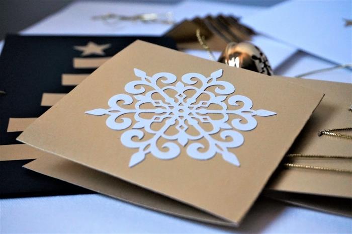 kahverengi kraft kağıdı ile yapmak için güzel Noel kartı, beyaz kart stoğundan kesilmiş kar taneleri şablonu
