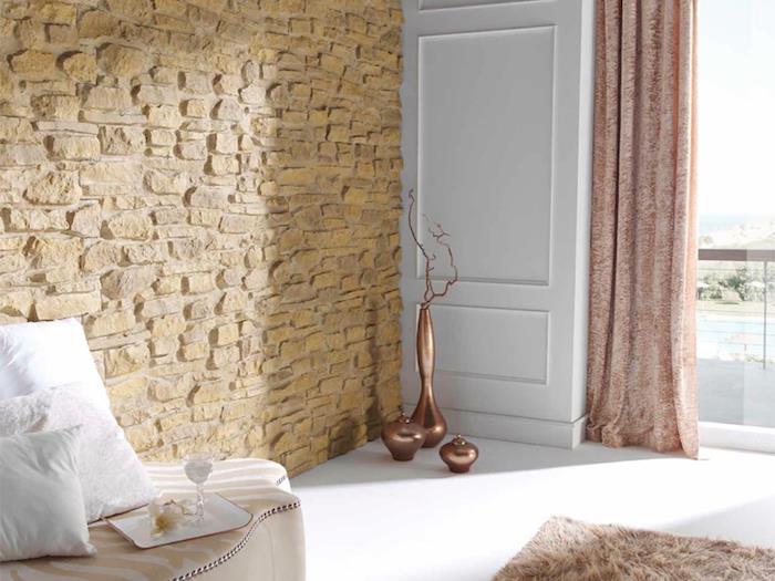 šviesi svetainė arba miegamasis su baltomis grindimis ir smėlio spalvos akmens siena