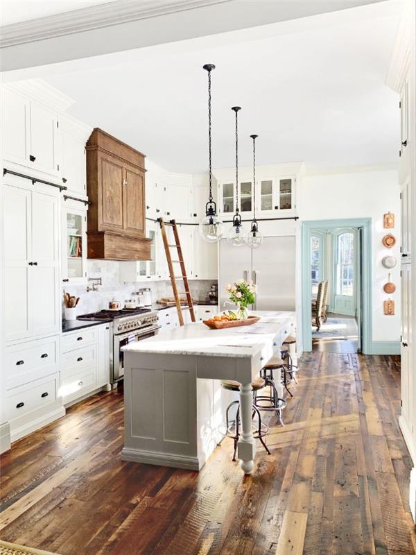 surov parket in lesena kuhinjska napa v retro elegantni podeželski kuhinji v beli barvi z industrijskimi vzmetenji in barskimi stoli